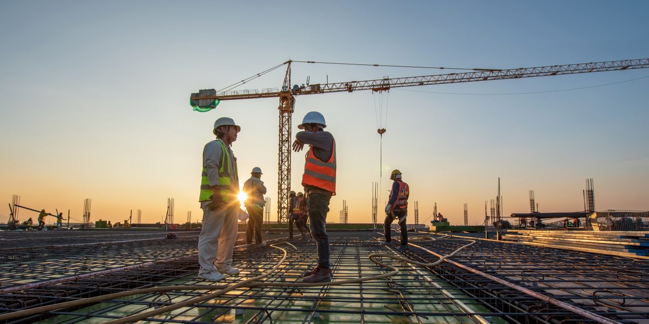 Construction engineer working at construction site during sunset time